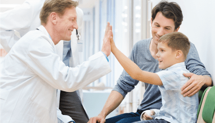 A doctor giving a high five to a young boy.