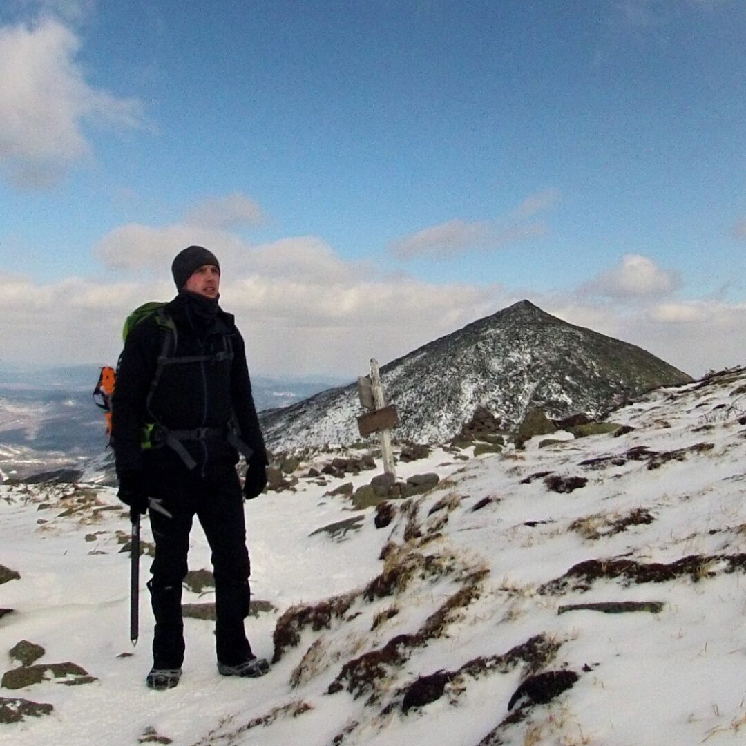 A man standing on top of a snow covered mountain.