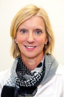 A woman in a white shirt with a black and white scarf.
