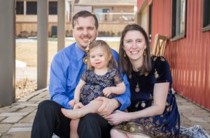 A Portrait of a Family Smiling With a Child