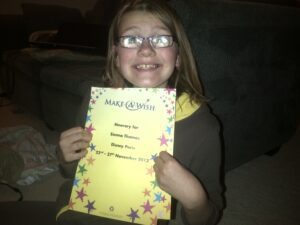 A young girl holding up a certificate.