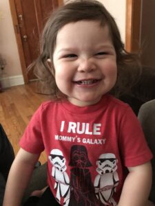 A toddler wearing a star wars t - shirt.