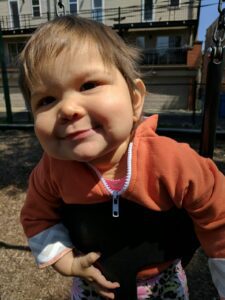 A little girl on a swing.