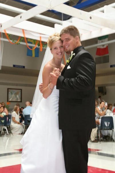 A bride and groom posing for a photo in a ballroom.