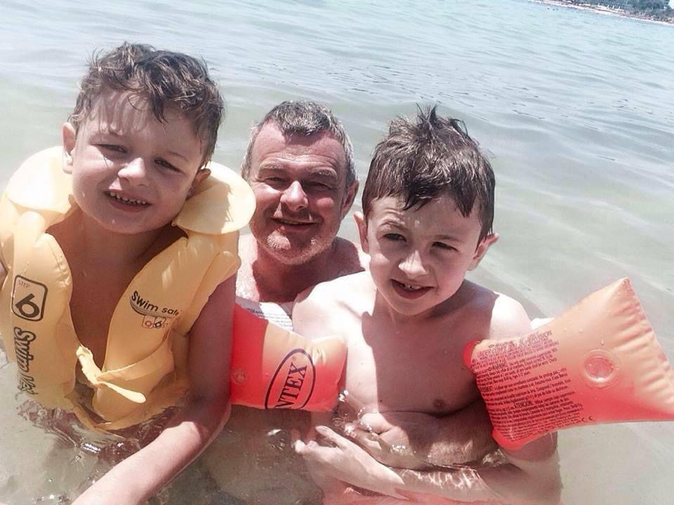 Father and sons in the water.