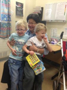 Two happy children with a smiling woman.