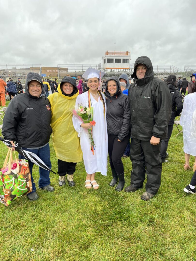 Family of five posing for a photo at a graduation ceremony.