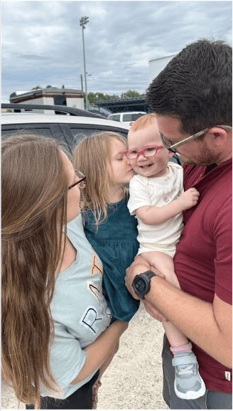 Family portrait with a baby wearing glasses.