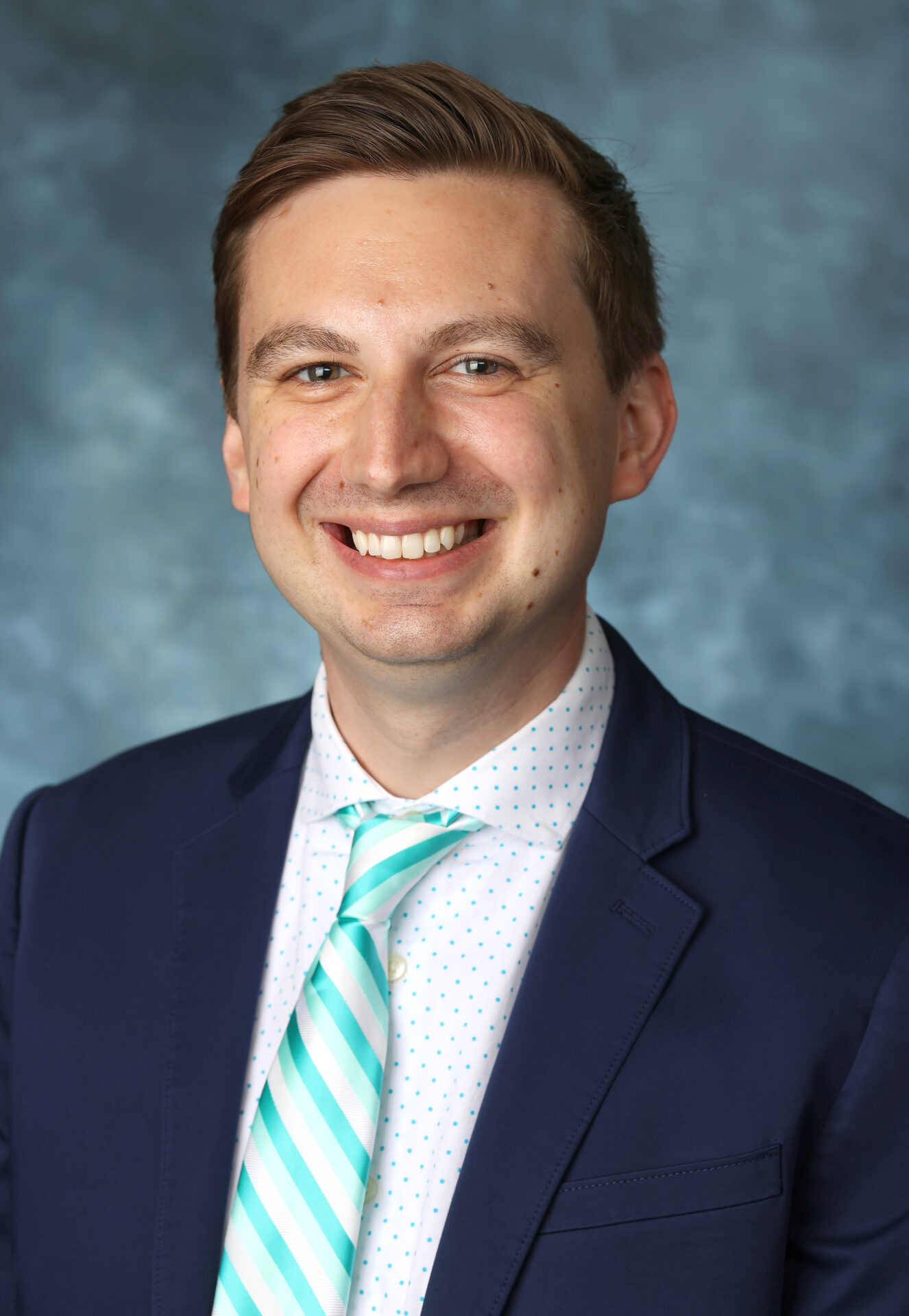 Smiling man in a suit and tie.