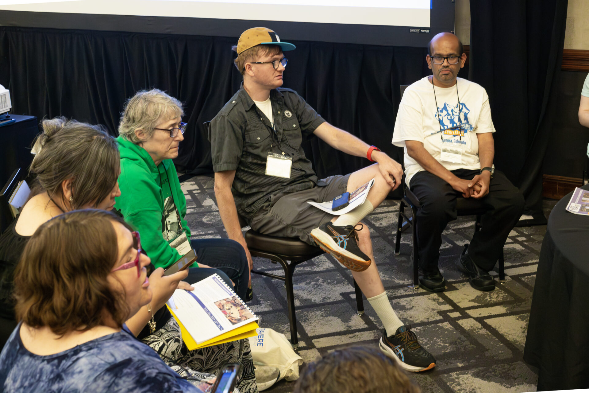 Four people sitting in chairs, talking.