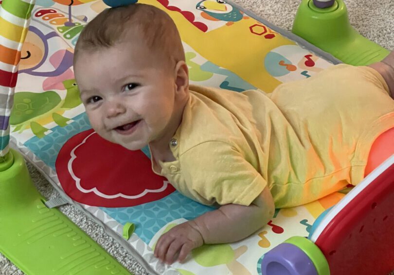 Baby playing on a colorful playmat.