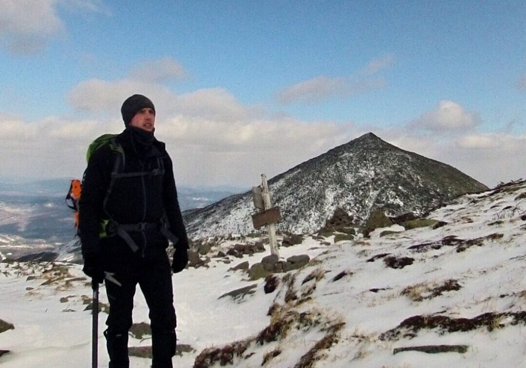 A man standing on top of a snow covered mountain.