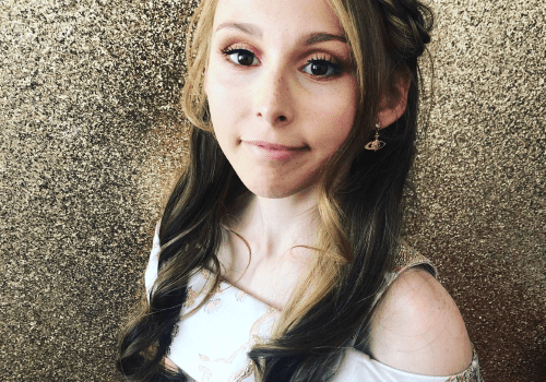 A young girl in a white dress posing for a photo.