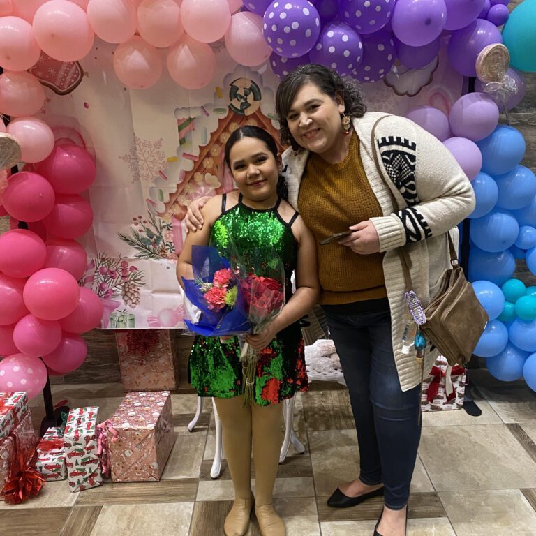 A young girl standing in front of balloons and balloons.