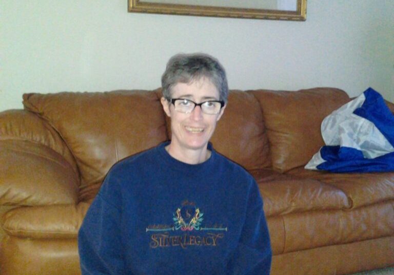 A woman sitting on the floor in a living room.