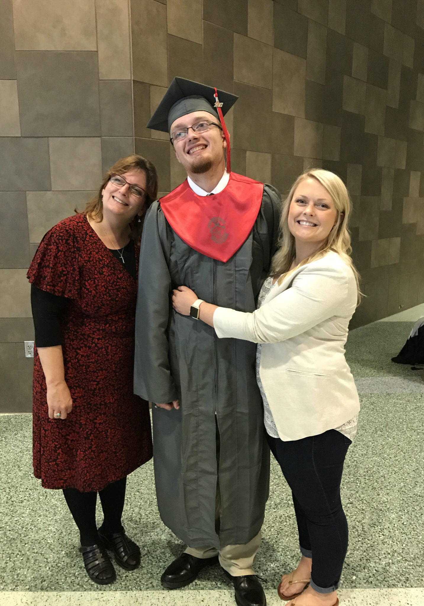 Two women posing for a photo in a graduation gown.