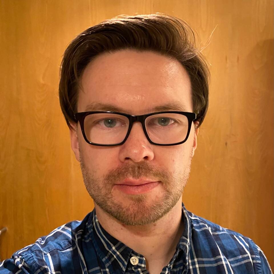 A man wearing glasses and a plaid shirt.