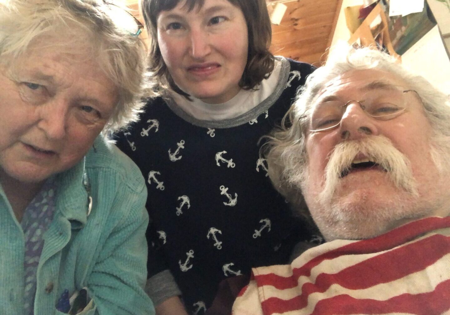 Three people posing for a selfie in a living room.