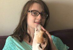 A woman sitting on a couch with a dog on her lap.