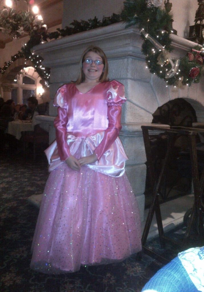 A woman dressed as a princess in a pink dress.