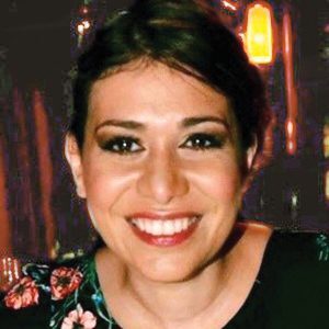 A woman smiling for the camera at a restaurant.