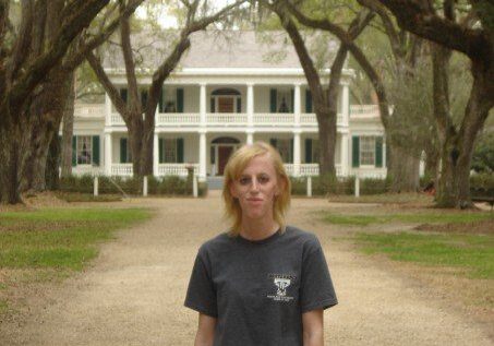 A woman standing in front of a house.