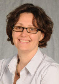 A woman wearing glasses and a white shirt.