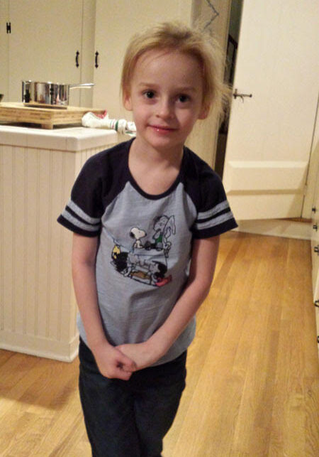 A little girl standing in a kitchen.