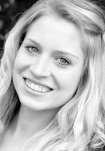 A black and white photo of a young woman smiling.