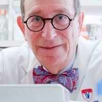 A man in a lab with glasses and a bow tie.