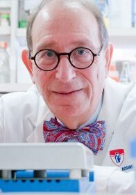 A man in a lab with glasses and a bow tie.